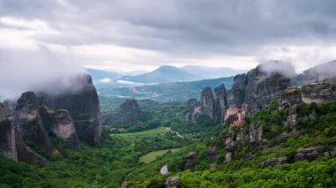 Yunanistan 'ın Kastraki kenti yakınlarındaki Meteora vadisinde Rousanou manastırı, St Nicholaos Anapafsas manastırı ve Varlaam manastırı ile hareket eden bulutların inanılmaz manzarası..