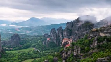 Yunanistan 'ın Kastraki kenti yakınlarındaki Meteora vadisinde Rousanou manastırı, St Nicholaos Anapafsas manastırı ve Varlaam manastırı ile hareket eden bulutların inanılmaz manzarası..
