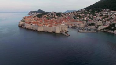 Hırvatistan 'ın ünlü eski Dubrovnik kentinin klibi, kuleleri, dar taş caddeleri ve Adriyatik deniz kıyısında kırmızı çatıları olan ve antik kent duvarları ve turkuaz Adriyatik denizi ile çevrili eski bir kasaba..