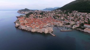 Hırvatistan 'ın ünlü eski Dubrovnik kentinin klibi, kuleleri, dar taş caddeleri ve Adriyatik deniz kıyısında kırmızı çatıları olan ve antik kent duvarları ve turkuaz Adriyatik denizi ile çevrili eski bir kasaba..