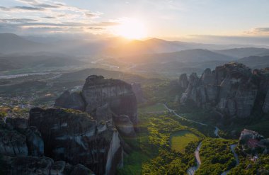 Amazing panoramic view of the Meteora Valley at the golden hour of sunset with Rousanou Monastery, Saint Nicholas Anapafsas Monastery and Varlaam Monastery near Kastraki, Greece. clipart