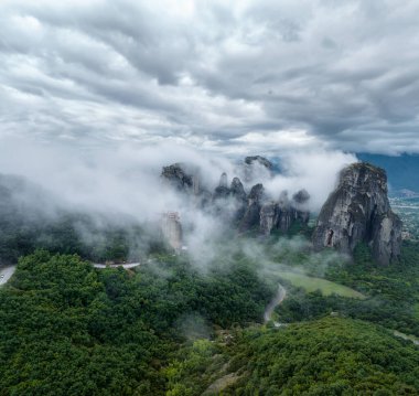 Meteora Vadisi 'ndeki kayaların şaşırtıcı panoramik manzarası gizemli bir şekilde Yunanistan' ın Kastraki kenti yakınlarında sis ve alçak bulutlarla örtülü..