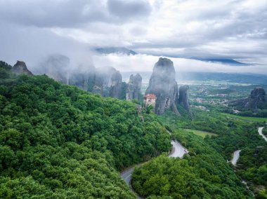 Meteora Vadisi 'ndeki kayaların şaşırtıcı panoramik manzarası gizemli bir şekilde Yunanistan' ın Kastraki kenti yakınlarında sis ve alçak bulutlarla örtülü..