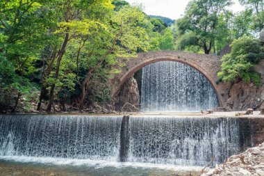 Yunanistan 'ın Trikala kenti yakınlarındaki Palaiokarya şelalelerinde bulunan eski taş köprüyle inanılmaz bir resim..