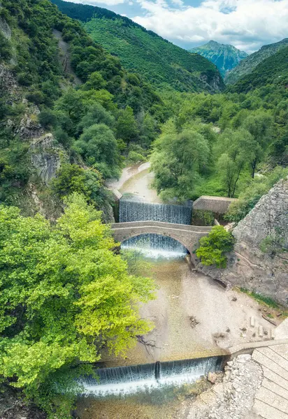 stock image Amazing aerial view with the picturesque old stone bridge at Palaiokarya waterfalls near Trikala in Greece.