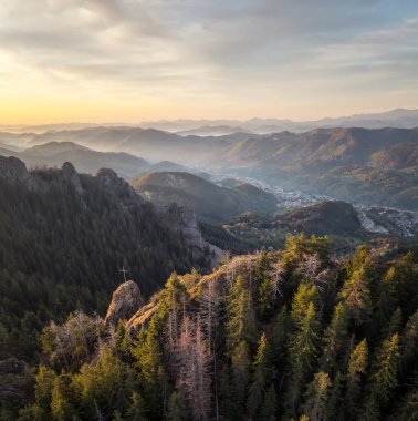 Gündoğumunda zengin bitki örtüsü ve ladin ile bir bahar dağı vadisi. Karanlık sık ormanlar ve yamaçlar arasında yuva yapmış küçük bir Smolyan kasabası, Rodopi Dağları, Bulgaristan.