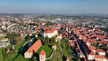 Slovenya 'daki Drava nehri boyunca Ptuj eski kasabasının evlerinin üstündeki tepede güzel Ptuj şatosunun yer aldığı hava videosu