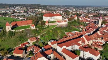 Slovenya 'daki Drava nehri boyunca Ptuj eski kasabasının evlerinin üstündeki tepede güzel Ptuj şatosunun yer aldığı hava videosu