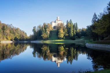 Hırvatistan 'ın kuzeyindeki Zagorje kentindeki görkemli eski şato ve Trakoscan Gölü' nün muhteşem sonbahar manzarası 