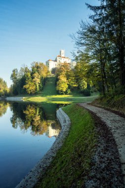 Hırvatistan 'ın kuzeyindeki Zagorje kentindeki görkemli eski şato ve Trakoscan Gölü' nün muhteşem sonbahar manzarası 