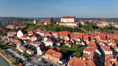 Slovenya 'daki Drava nehri boyunca Ptuj eski kasabasının evlerinin üstündeki tepede güzel Ptuj şatosunun yer aldığı hava videosu