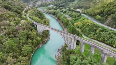 Solkan Köprüsü etrafındaki hava videosu - Slovenya 'nın batısındaki Nova Gorica yakınlarındaki Soca Nehri üzerindeki dünyanın en uzun taş kemerli demiryolu köprüsü.