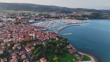 Eski kenti ve kırmızı çatıları olan binaları, ana gezinti alanı, Adriyatik sahil kıyısı Slovenya 'da botları olan marinaları olan manzaralı Izola kasabasının hava panoramik videosu.