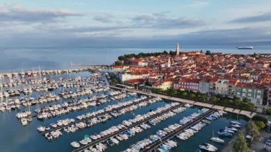 Eski kenti ve kırmızı çatıları olan binaları, ana gezinti alanı, Adriyatik sahil kıyısı Slovenya 'da botları olan marinaları olan manzaralı Izola kasabasının hava panoramik videosu.