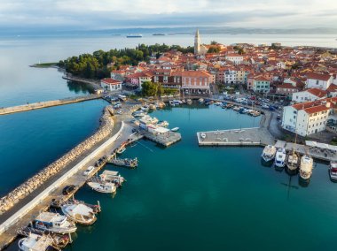 Eski kenti ve kırmızı çatıları olan binaları, ana gezinti alanı, Adriyatik sahil kıyısı Slovenya 'da tekneleri olan marinayı gösteren manzaralı Izola kasabası..