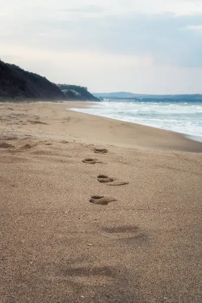 Bulgaristan 'ın Karadeniz kıyısında uzun ve boş kumlu bir sahil manzarası, ayak sesleri ve yumuşak deniz dalgalarıyla birlikte..