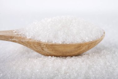 Beyaz arka planda beyaz şekerli tahta kaşık.