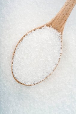 Beyaz arka planda beyaz şekerli tahta kaşık.