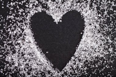 Siyah arkaplanda beyaz şeker kalp