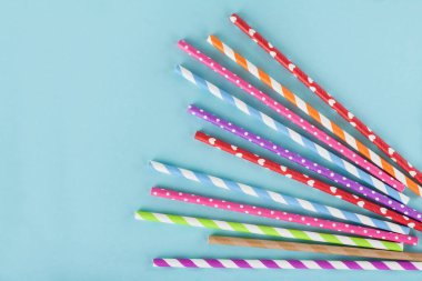 Mavi arkaplanda farklı renkli kağıt pipetleri