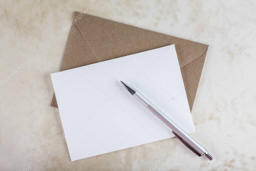 Brown envelope, blank invitation cart and pen.