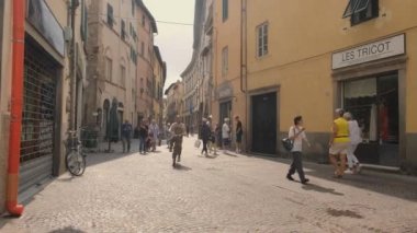 Lucca, İtalya - 31 Ağustos 2023: Tarihi merkezdeki yaya caddesinde yürüyen turistler ve vatandaşlar. Yüksek kalite 4k görüntü