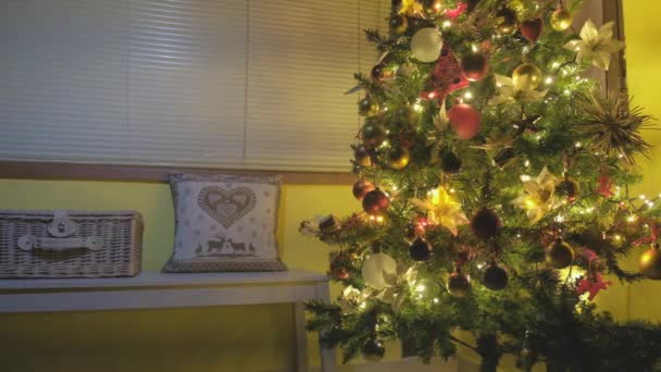 圣诞树上装饰着金球和雪花 背景上挂着彩灯 冬天的主题枕头在一个高贵的家角落里 — 图库视频影像