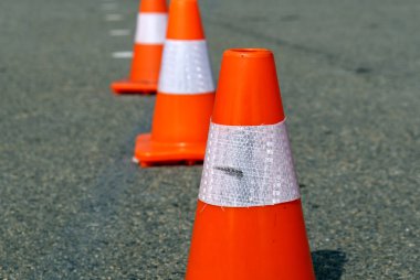 Koyu asfalt üzerinde parlak turuncu trafik konileri. Yüksek kalite fotoğraf