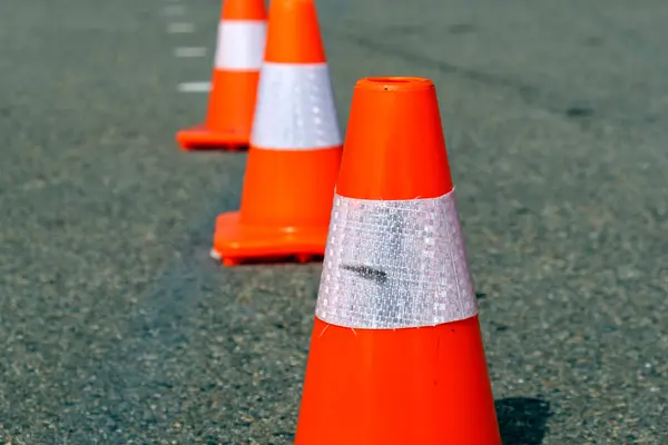 Koyu asfalt üzerinde parlak turuncu trafik konileri. Yüksek kalite fotoğraf
