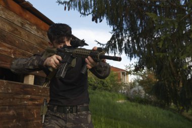 a young soldier stationed behind a shed. High quality photo clipart