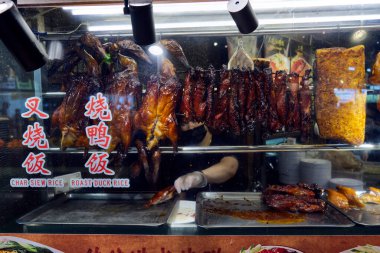 Koyu renkli parlak derili kızarmış ördekler, sergileniyor, zengin, karamelize bir doku yayıyor, keskin doğal ışıklandırma detaylarıyla. Yüksek kalite fotoğraf