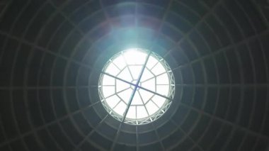 Endüstriyel bir çatıda dairesel bir pencereden parlayan güneş, baş dönmesi etkisi. Yüksek kalite 4k görüntü