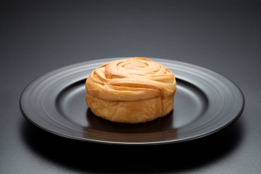 Siyah arka planda siyah bir tabakta taze ekmek.