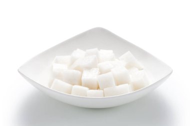 Beyaz arka planda izole edilmiş bir tabakta doğranmış beyaz turp.