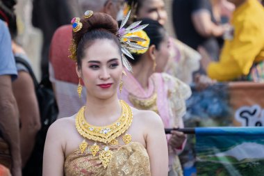 Chiang Mai, Thailand - February 4, 2023: Beautiful colorful Chiang Mai Flower Festival 2023 Parade on the old town street with fresh flowers decorated cars and people in traditional costumes.