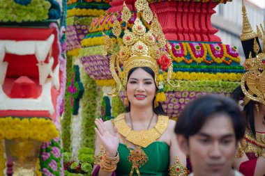 Chiang Mai, Thailand - February 4, 2023: Beautiful colorful Chiang Mai Flower Festival 2023 Parade on the old town street with fresh flowers decorated cars and people in traditional costumes.