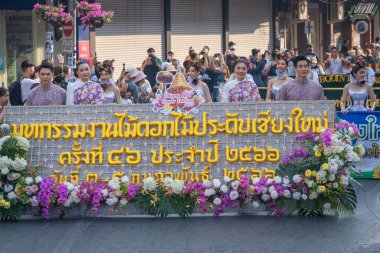 Chiang Mai, Thailand - February 4, 2023: Beautiful colorful Chiang Mai Flower Festival 2023 Parade on the old town street with fresh flowers decorated cars and people in traditional costumes.