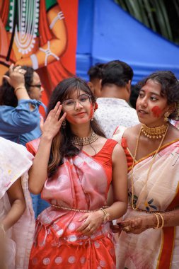 Geleneksel Bengali kıyafeti giyen ve Durga puja 'nın son gününde Sindur Khela' da puja pandalına katılan güzel genç ve çekici bir kadının portresi. Kolkata, Hindistan 5 Ekim 2022