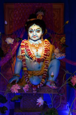 Idol of Goddess Laddu Gopal or little Lord Krishna at a decorated puja pandal in Kolkata, West Bengal, India on March 26, 2024. clipart