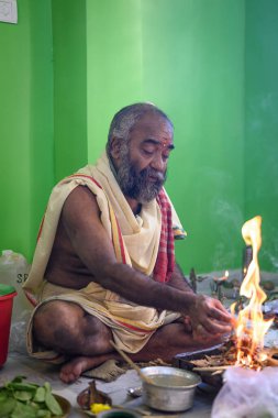 Brahmin, geleneksel bir Hindu ateş ayini olan puja sırasında Yajna 'yı icra eder. Kolkata, Batı Bengal, Hindistan 09 Ekim 2022