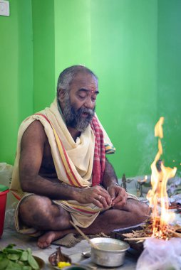 Brahmin, geleneksel bir Hindu ateş ayini olan puja sırasında Yajna 'yı icra eder. Kolkata, Batı Bengal, Hindistan 09 Ekim 2022