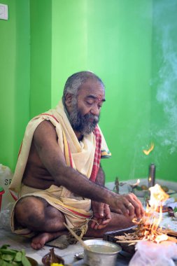 Brahmin performs the Yajna during puja, a traditional Hindu fire ritual. Kolkata, West Bengal, India on October 09, 2022 clipart