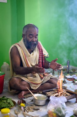 Brahmin, geleneksel bir Hindu ateş ayini olan puja sırasında Yajna 'yı icra eder. Kolkata, Batı Bengal, Hindistan 09 Ekim 2022