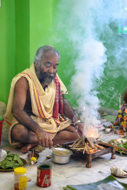 Brahmin, geleneksel bir Hindu ateş ayini olan puja sırasında Yajna 'yı icra eder. Kolkata, Batı Bengal, Hindistan 09 Ekim 2022