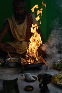 Brahmin, geleneksel bir Hindu ateş ayini olan puja sırasında Yajna 'yı icra eder. Kolkata, Batı Bengal, Hindistan 09 Ekim 2022