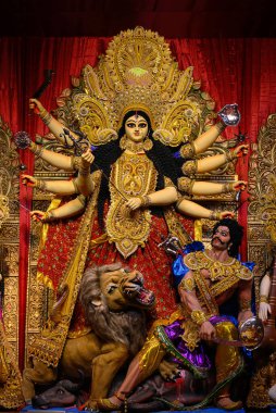 Idol of Goddess Devi Durga at a decorated puja pandal in Kolkata, West Bengal, India. Durga Puja is a popular and major religious festival of Hinduism that is celebrated throughout the world. clipart