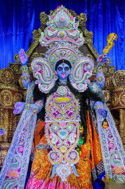 Idol of Goddess Maa Kali at a decorated puja pandal in West Bengal, India, during Kali puja, a famous religious festival of Hinduism. clipart