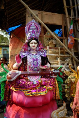 Clay idol of Goddess Devi Saraswati is in preparation for the upcoming Saraswati Puja at a pottery studio in West Bengal, India on February 03, 2022 clipart