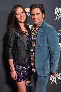 Los Angeles, CA USA - December 4, 2024: Caitlin McHugh Stamos, John Stamos attends the premiere of the film The Invisible Raptor. clipart