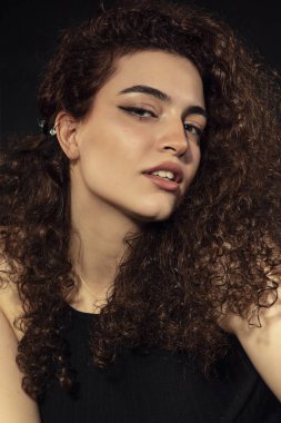 Genç, güzel, beyaz tenli ve kızıl saçlı bir kızın portre fotoğrafları. Portre, genç ve yetenekli bir aktris adayının vesikalık fotoğrafları, siyah bir arkaplanda çekilmiş. Gülümseyen bir yüz ve duygusal bakışlar.